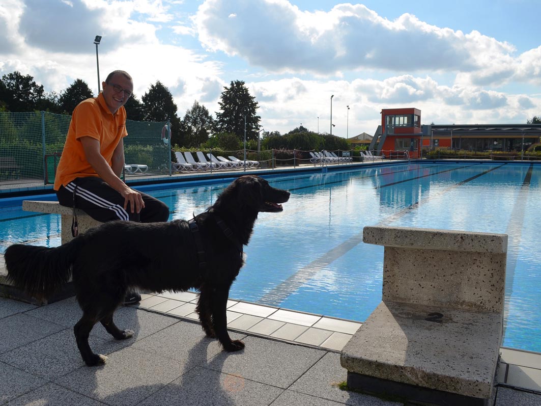 Schwimmmeister Malte Wollenburg nimmt mit Hündin Lissi schon mal die Wasseroberfläche in Augenschein. Am 1. Oktober ist das Becken dann frei für alle Hunde. Foto: Samtgemeinde.